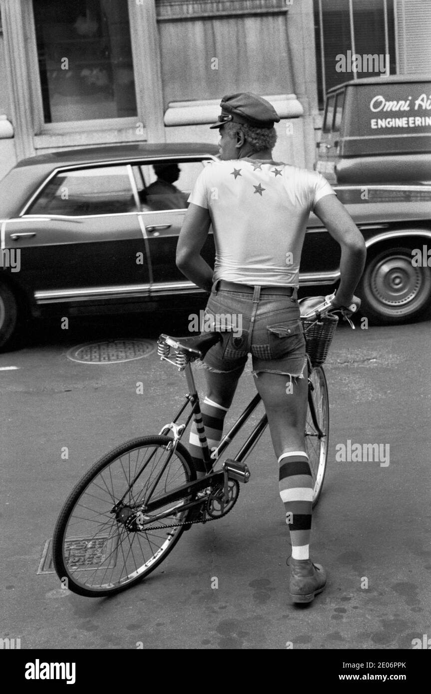 Gay African American man 1970s US. Dressed fashionably, tight short shorts long socks and peaked cap riding a bicycle Manhattan New York USA 1972 HOMER SYKES Stock Photo