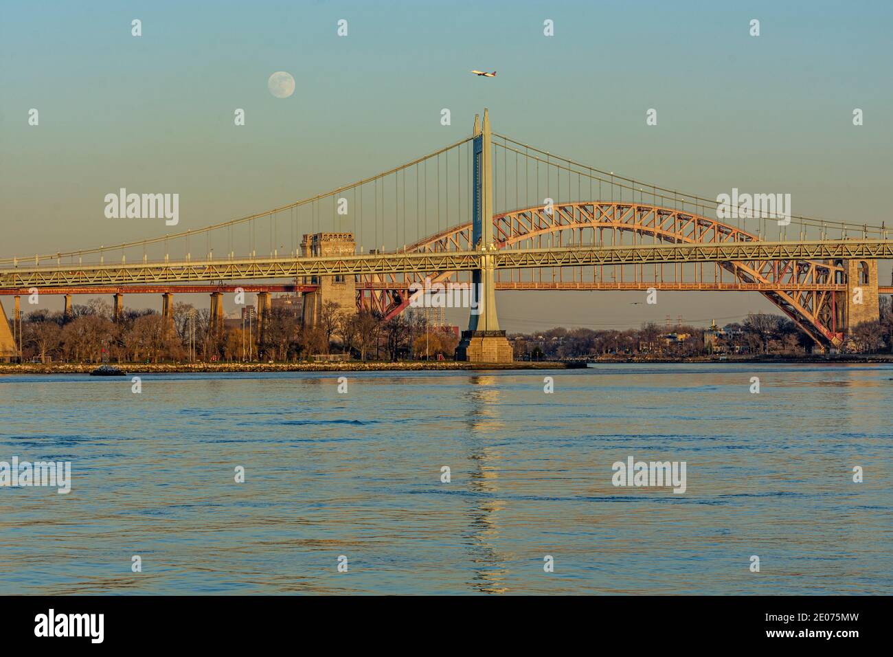 Moon rising over New York City bridges and East River Stock Photo