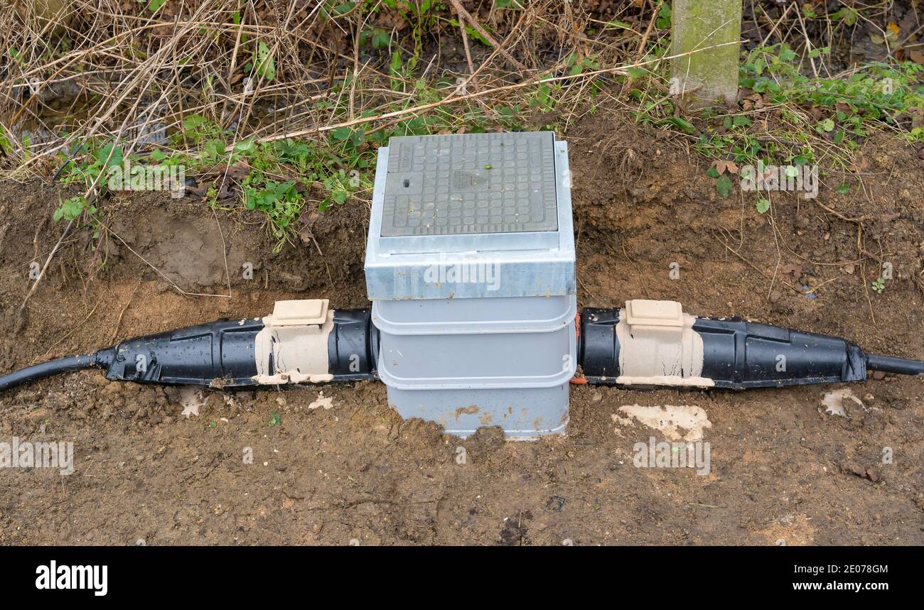A newly installed electrical underground link box with armoured cable connectors. Hertfordshire. UK Stock Photo