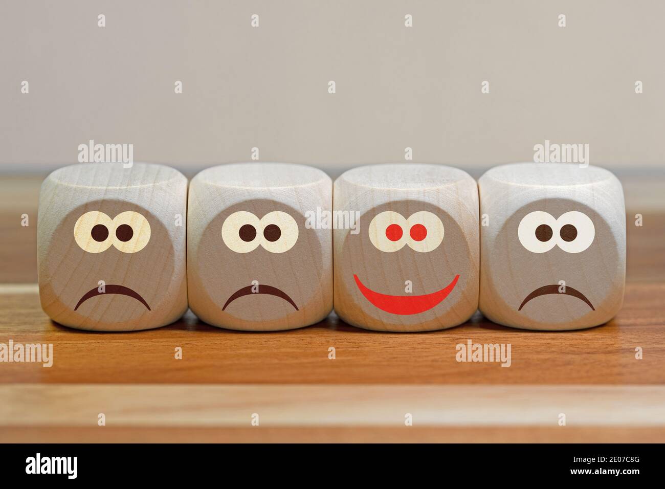 Dice with three negative and one positive facial expression Stock Photo