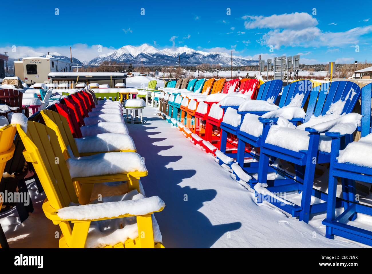Colorful Adirondack style chairs in fresh snow; retail store; Poncha Springs; Colorado; USA Stock Photo