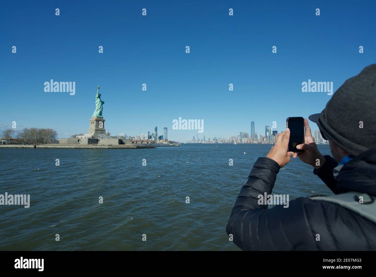 Tourist taking a photo of the Statue of Liberty New York, New York City ...