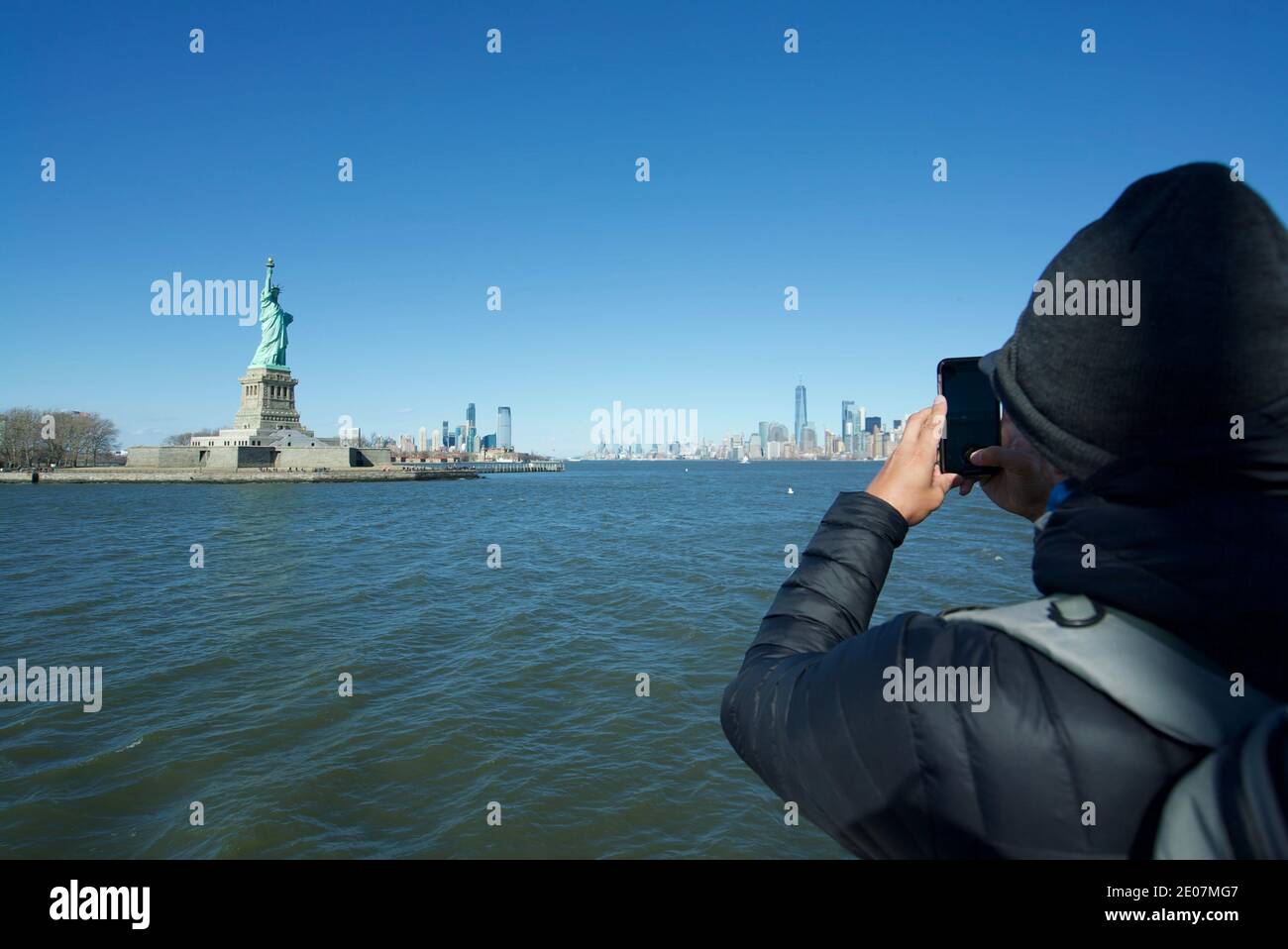 Tourist taking a photo of the Statue of Liberty New York, New York City Statue, Liberty Island New York, NYC. Phone photography. Tourists and visitors Stock Photo