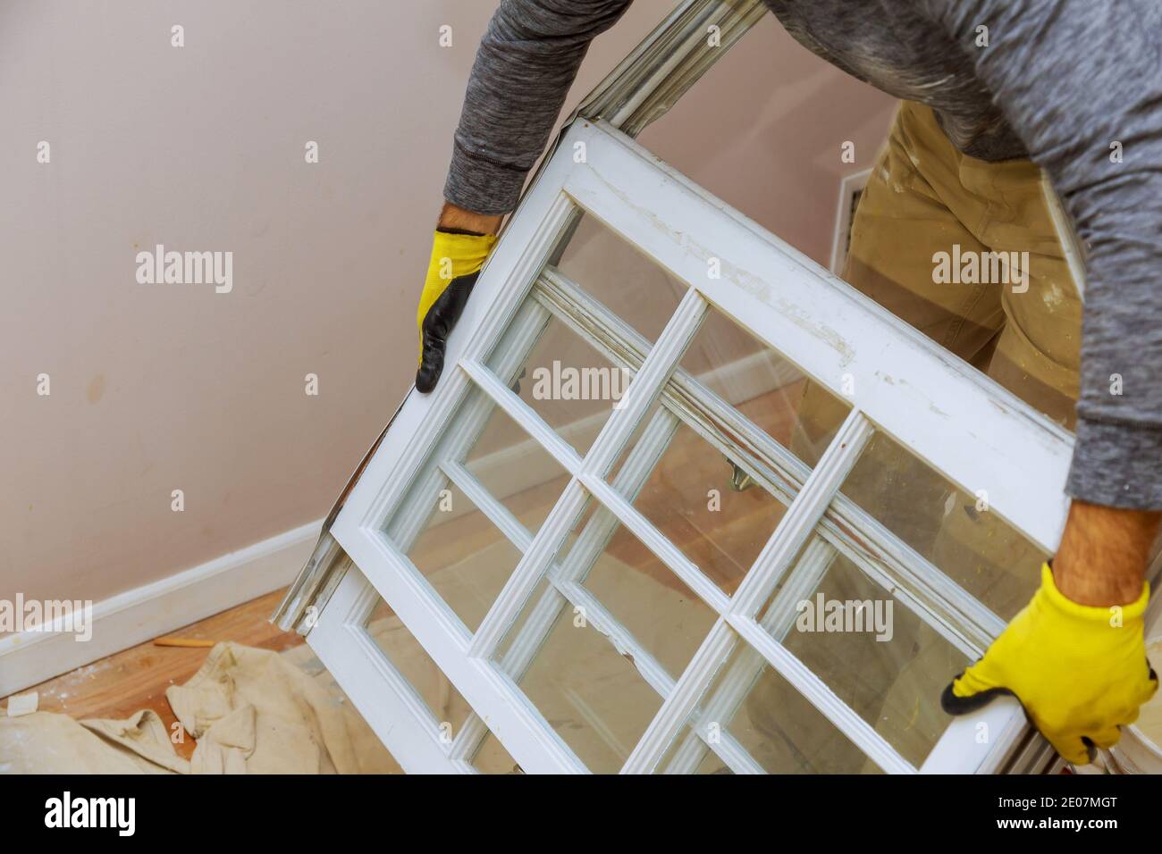 A carpenter with process of removing an old wooden window from an ...