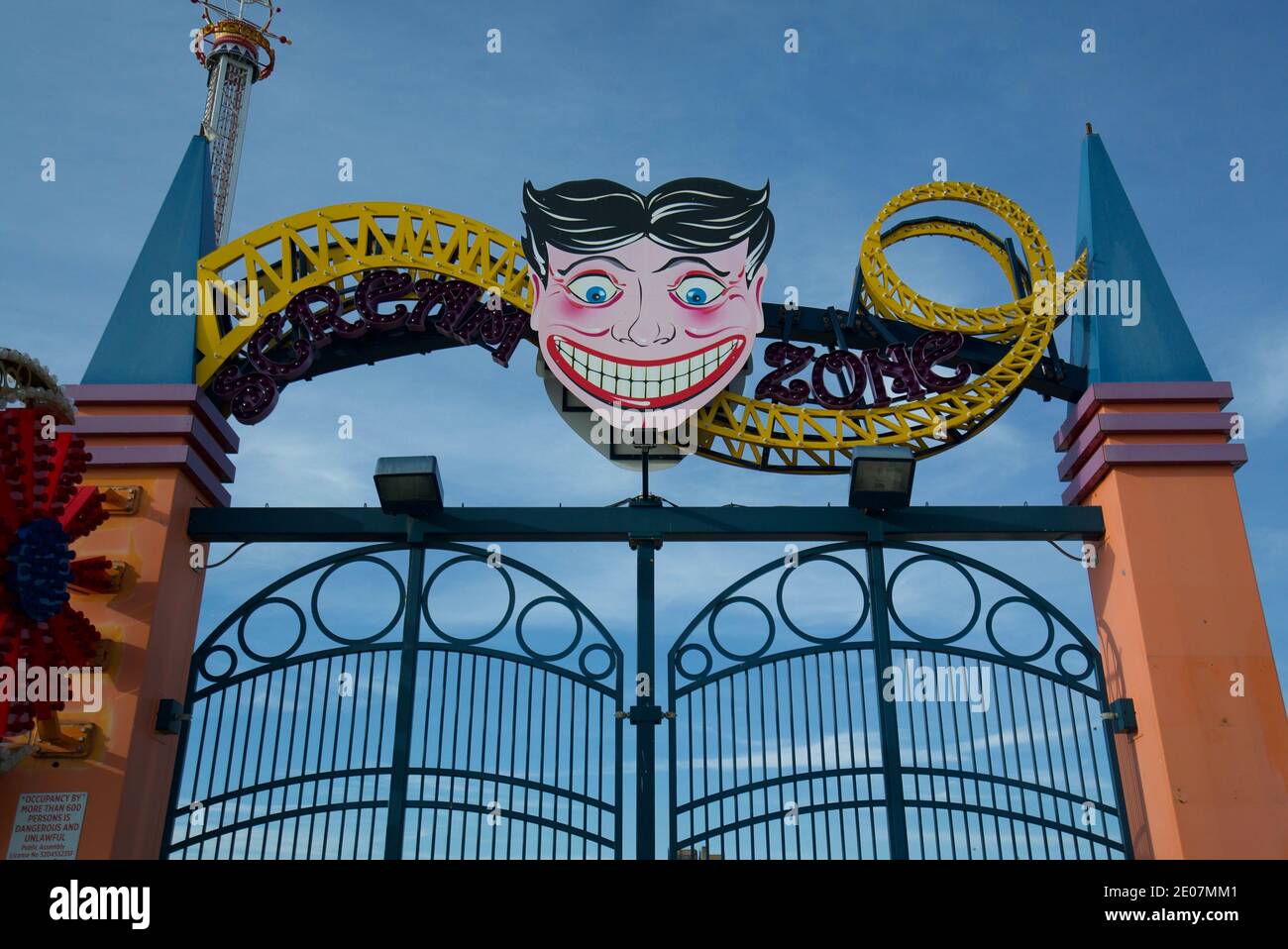 Entrance gate to Coney Island Scream Zone, New York, Amusement Park, showing the smiling man AKA The Steeplechase Face or 'Tillie'. Stock Photo