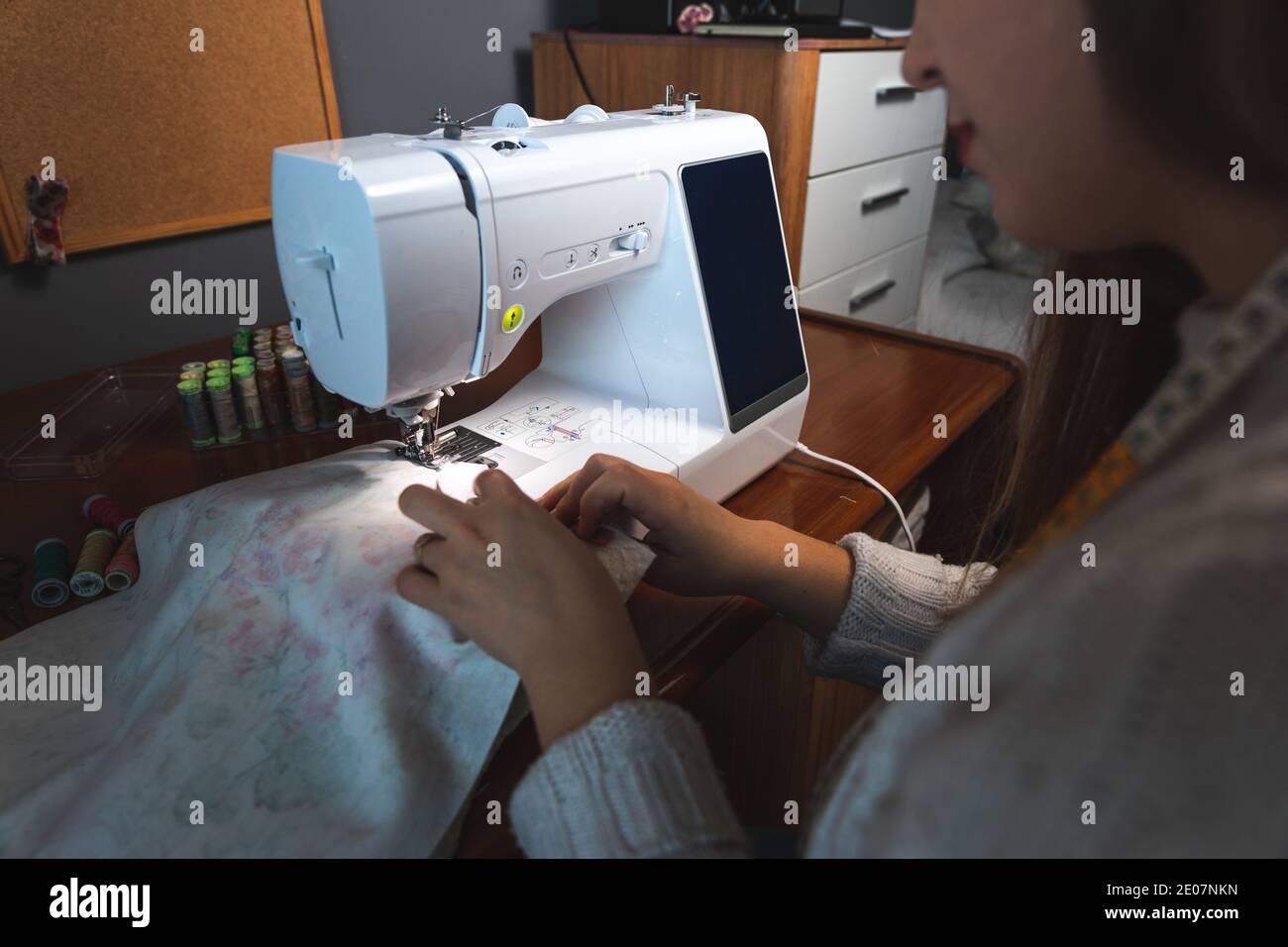 Young woman using a sewing machine Stock Photo - Alamy