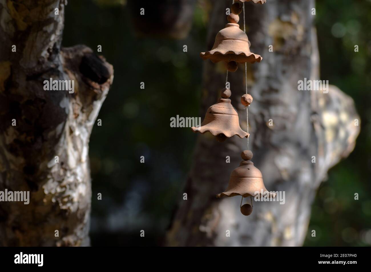 Beautiful terracotta Windchime bell hanging. Blurred background. Traditional clay mud pottery hand made windchime close up made in India Stock Photo