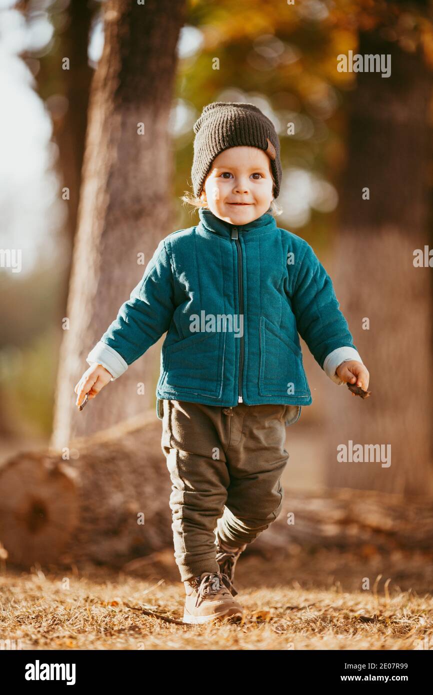 joyful-child-runs-a-boy-dressed-in-a-green-jacket-and-brown-pants