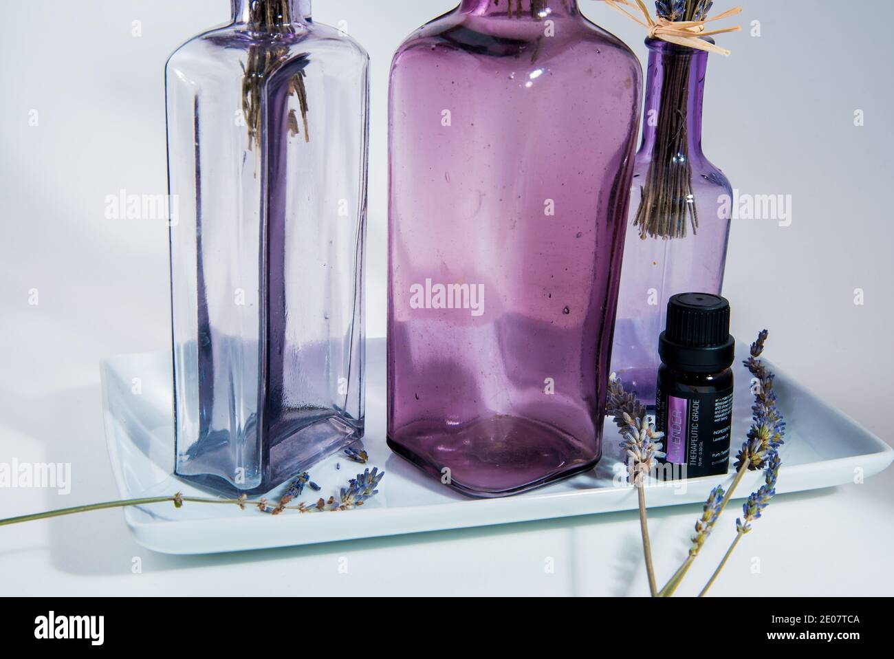 Lavender plants in bottles with essential oils, on a white background ...