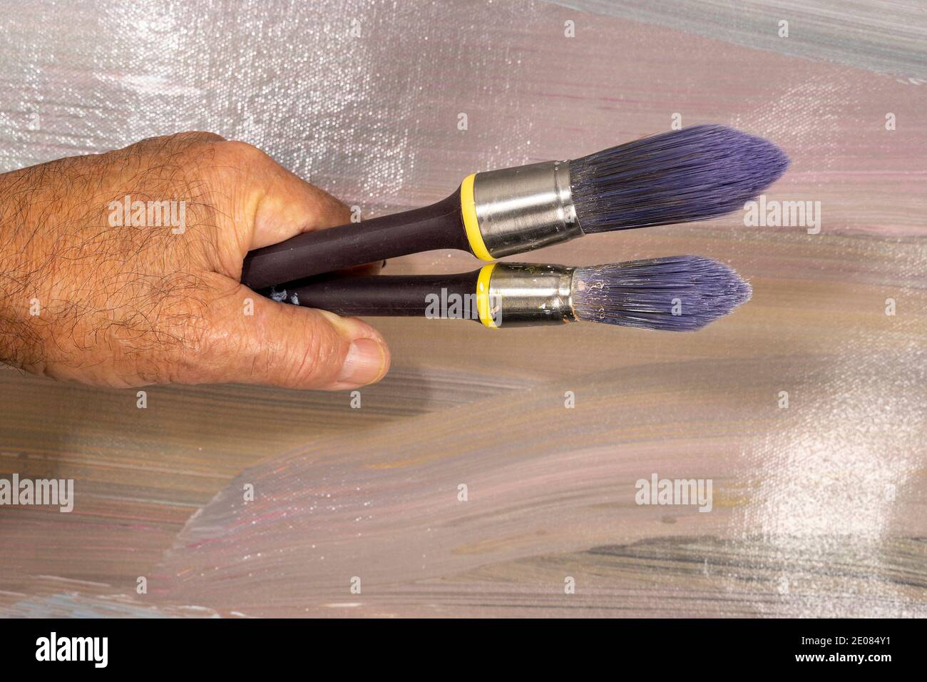 Brushes for painting  lying on an old canvas painted with oil paints Stock Photo