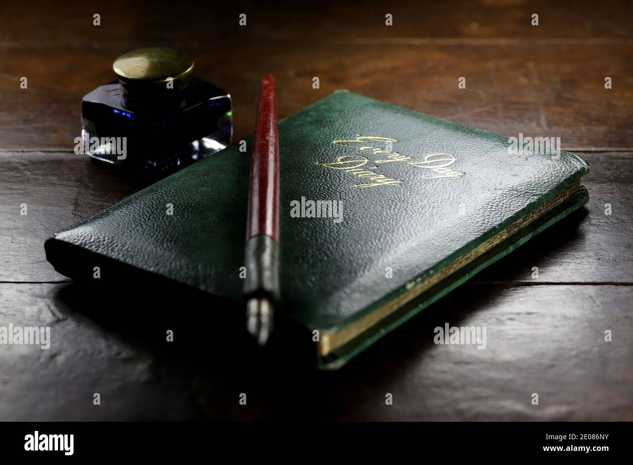 closed diary with dib pen and inkwell on desktop Stock Photo