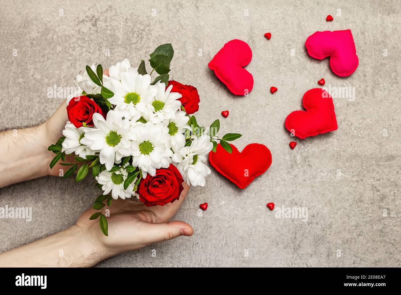 Valentine S Day Or Happy Birthday Concept Male Hands Are Holding A Bouquet Of Flowers Scattered Handmade Felt Hearts Grey Stone Concrete Background Stock Photo Alamy