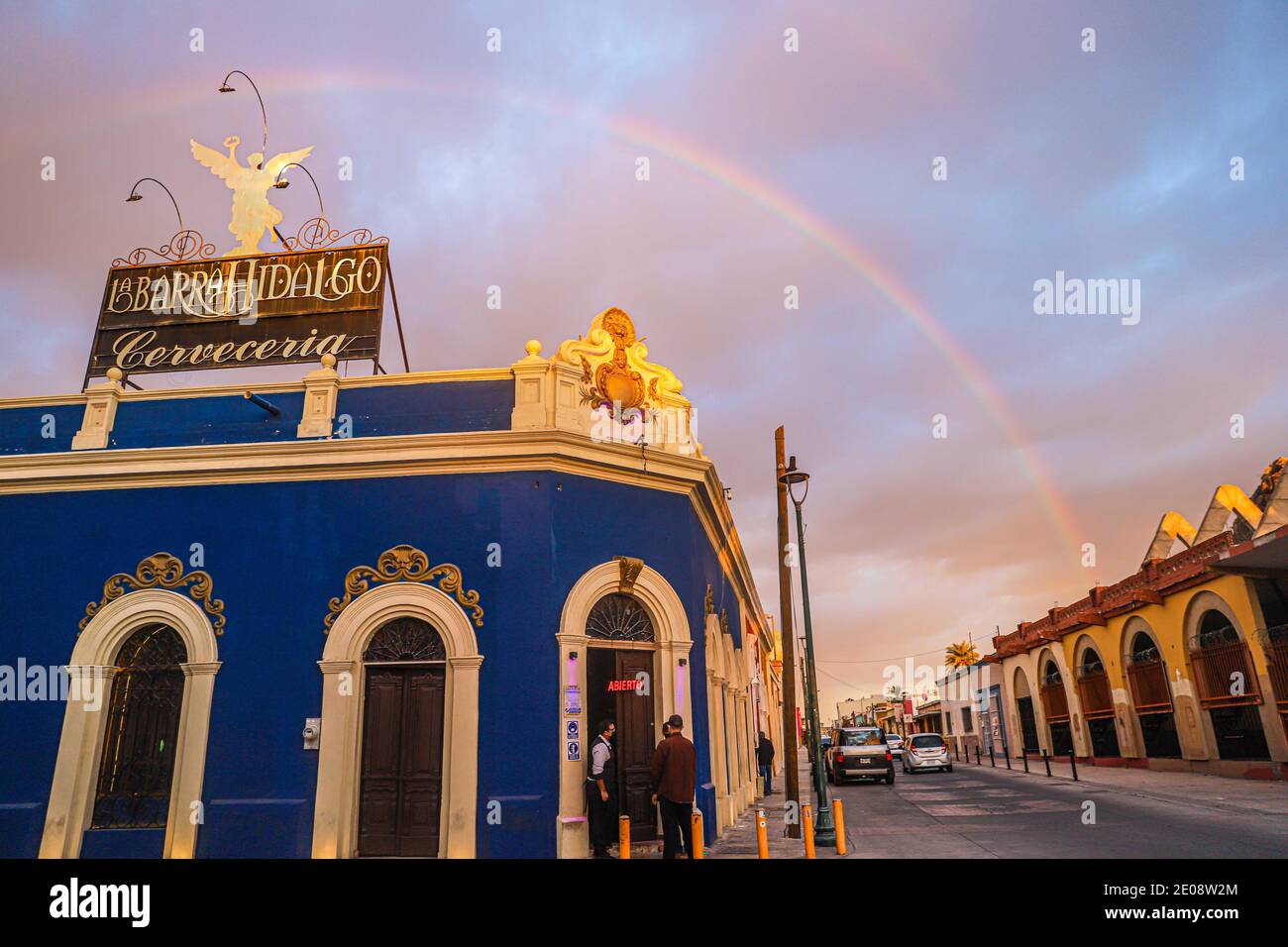 A rainbow is observed over the Barra Hidalgo bar or brewery on a cloudy day  during a winter afternoon on December 29, 2020 in Hermosillo, Mexico.  (Photo by Luis Gutierrez / Norte