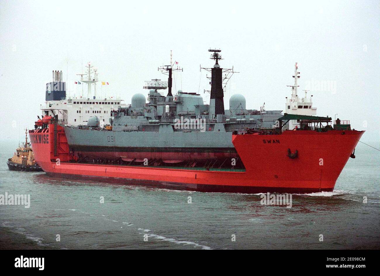 AJAXNETPHOTO. 08 DECEMBER, 2002. PORTSMOUTH. ENGLAND. - PIGGY BACK - THE SEMI SUBMERSIBLE HEAVY LIFT SHIP SWAN ENTERS PORTSMOUTH HARBOUR TODAY LOADED WITH THE ROYAL NAVY'S DESTROYER NOTTINGHAM WHICH RAN AGROUND OFF HOWE ISLAND IN THE PACIFIC EARLIER THIS YEAR.  PHOTO:JONATHAN EASTLAND/AJAX  REF:(PMO2)21012 10 Stock Photo