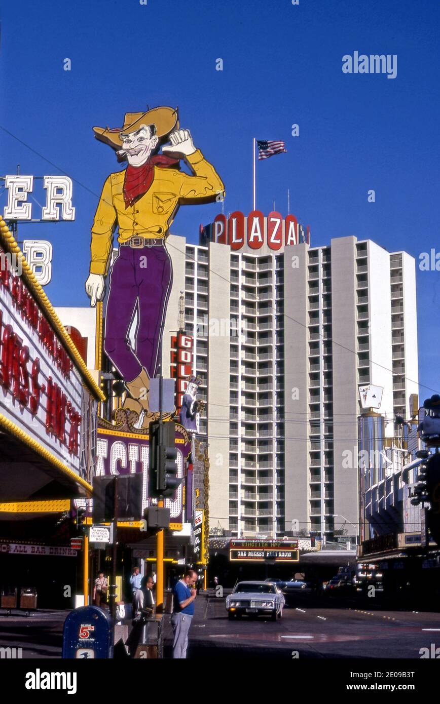 Fremont Street view with Pioneer Club cowboy sign and the Plaza Hotel when the street was uncovered circa 1970s in  Las Vegas, NV Stock Photo