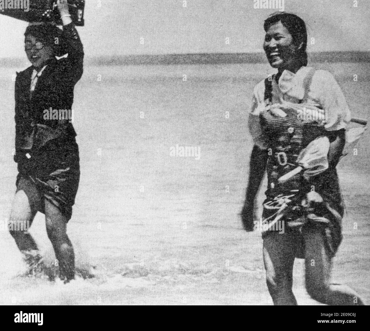 Comfort women crossing a river following soldiers during World War II Stock Photo