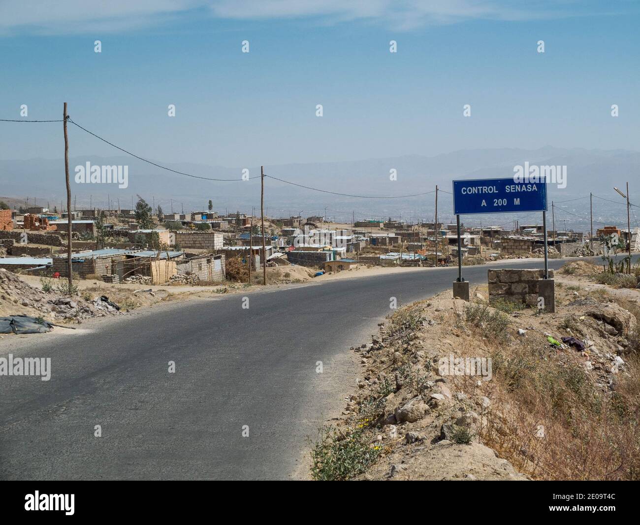 A road on the outskirts of Arequipa, Peru. Small concrete huts are scattered through the area inhabited by some of the city's lower income residents Stock Photo