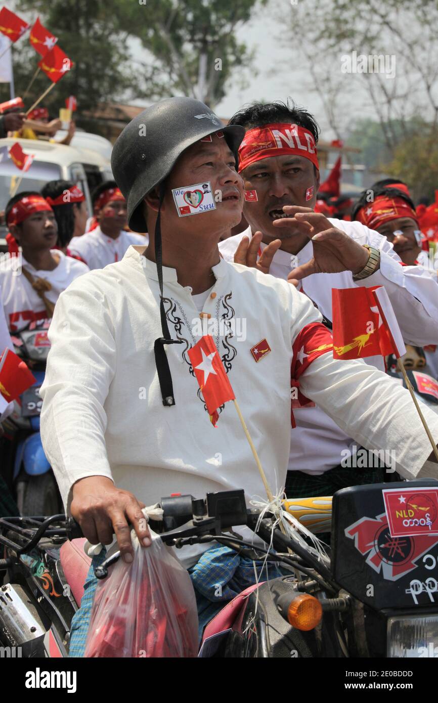 A man wearing a German army helmet and NLD red flag is seen among thousands of supporters who gathered for a campaign meeting of Nobel Peace Prize winner and National League for Democracy (NLD) chairman Aung San Suu Ky, in Lashio, northern Shan State, Myanmar on March 17, 2012. Photo by Christophe Loviny/ABACAPRESS.COM Stock Photo