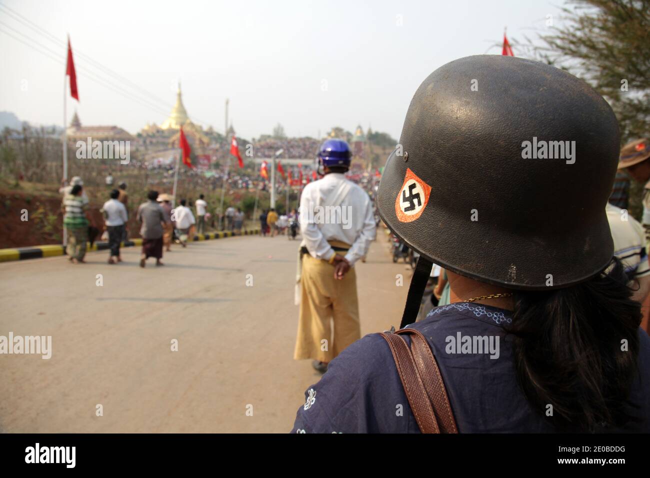 A woman wearing a German army helmet with a nazi swastika as a motorbike helmet on her way to join thousands of supporters for a campaign meeting of Nobel Peace Prize winner and National League for Democracy (NLD) chairman Aung San Suu Ky, in Lashio, northern Shan State, Myanmar on March 17, 2012. Photo by Christophe Loviny/ABACAPRESS.COM Stock Photo
