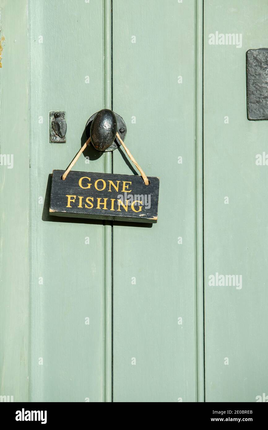 Gone Fishing sign on a cottage door in Lower Slaughter. Cotswolds, Gloucestershire, England Stock Photo