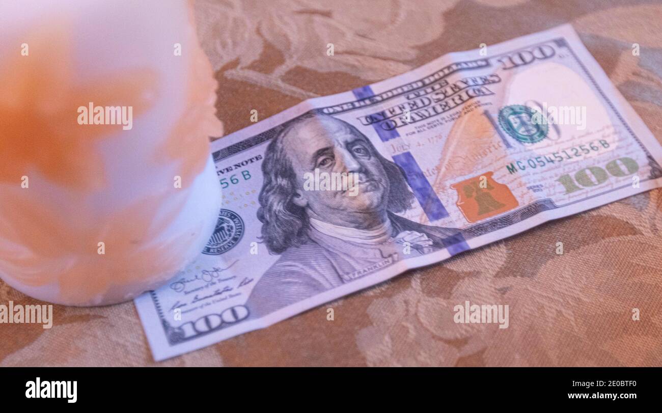 December 30, 2020: A $100 dollar bill sits in a home in San Diego, California on Wednesday, December 30th, 2020. The United States Senate is currently debating whether eligible Americans should receive $600 or $2,000 stimulus checks. The Caring for Americans with Supplemental Help (CASH) Act passed the United States House of Representatives last week. Credit: Rishi Deka/ZUMA Wire/Alamy Live News Stock Photo