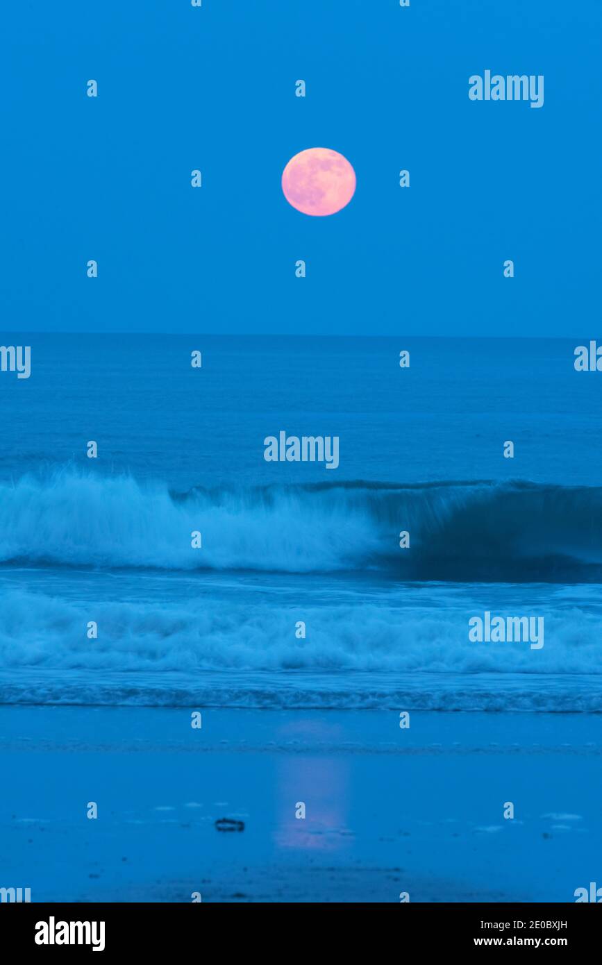 Full strawberry moon rises over the Atlantic Ocean Stock Photo