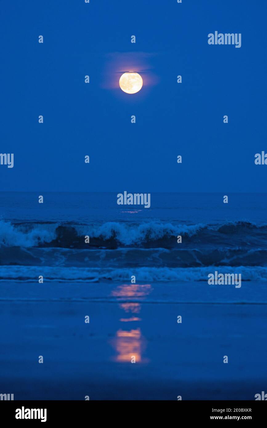 Full strawberry moon rises over the Atlantic Ocean Stock Photo