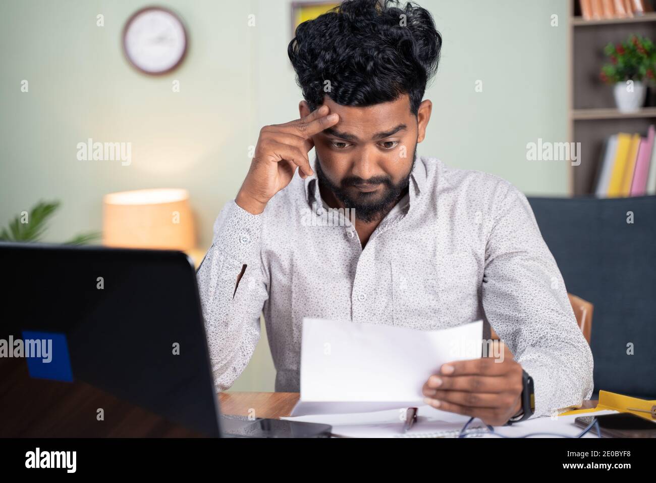 Young man got disappointed after reading mail paper letter - Concept of bad news, job termination, business deadline or eviction notice. Stock Photo