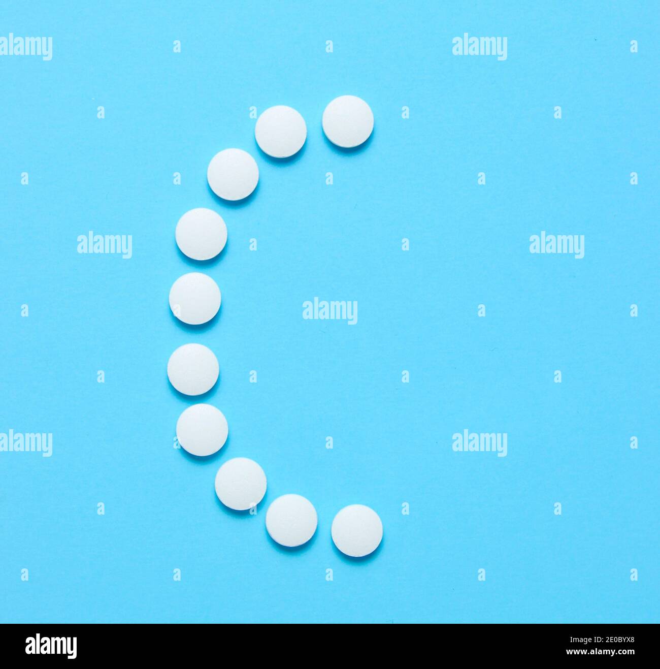 Vitamin C. Letter C from white pills on blue background. Minimalistic ...