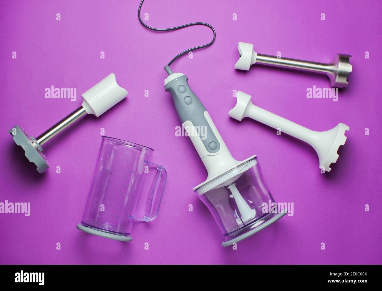 Electric hand blender with nozzles on a purple background. Top view