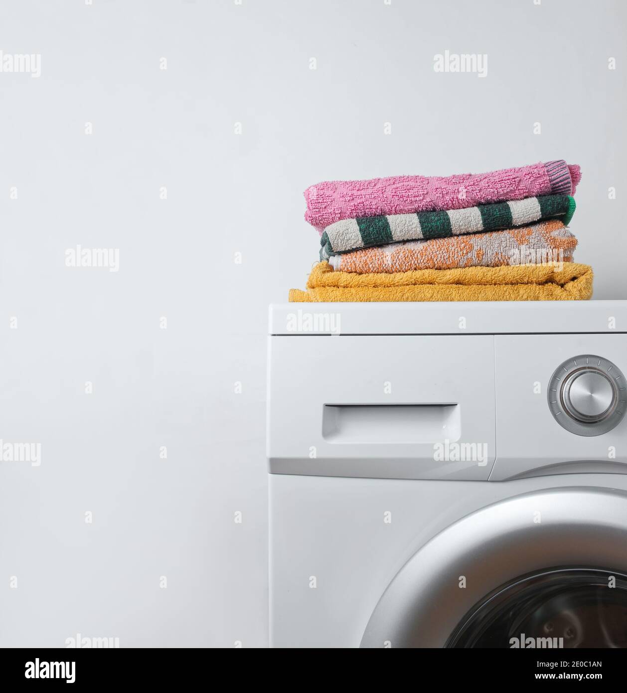 Stack of towels on the washing machine. White background Stock Photo