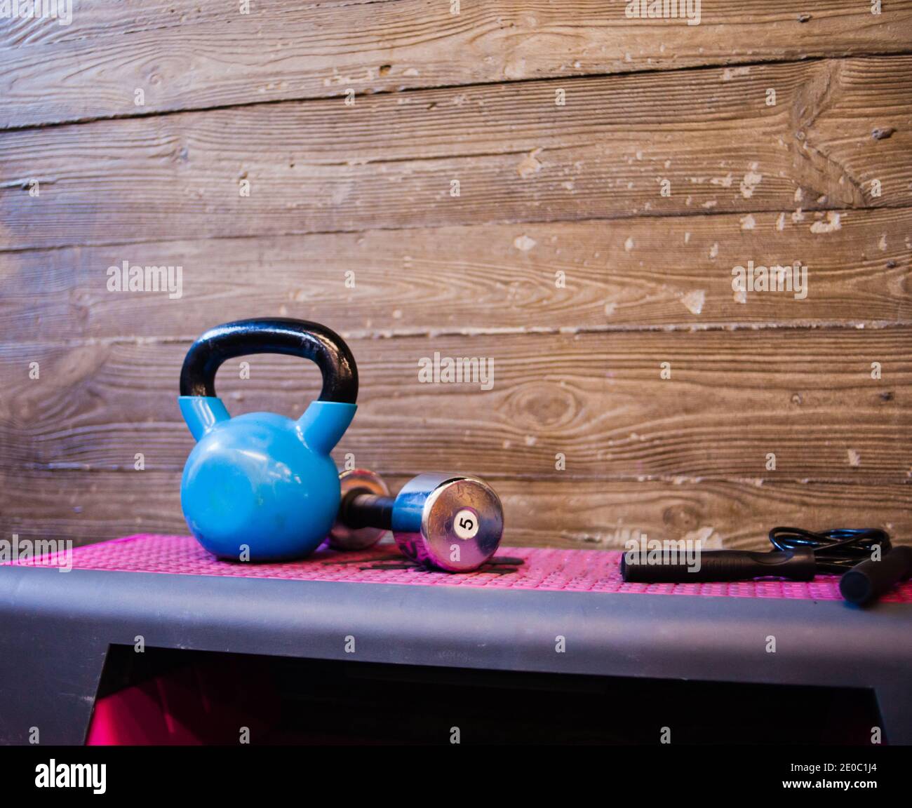Functional training concept. Kettlebell, dumbbell, jump rope stand on a ...