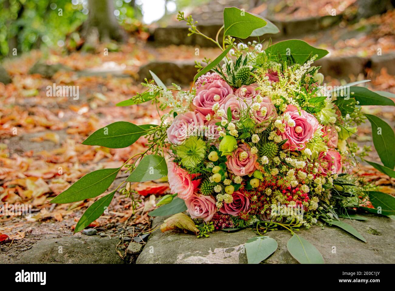 Brautstrauß rote Rosen mit Steintreppe und Laub Stock Photo