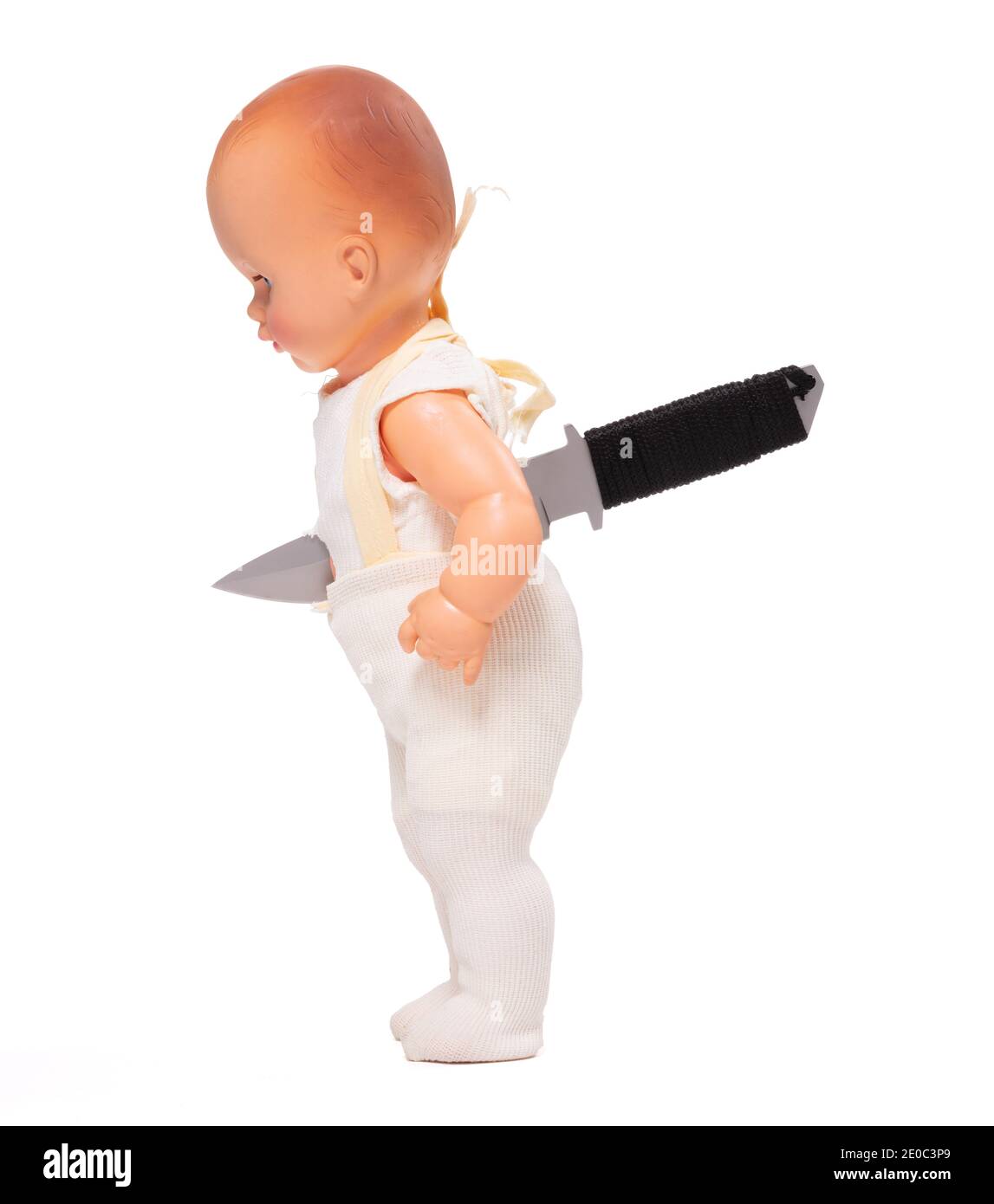 Broken old doll, knife in back, isolated on white background Stock