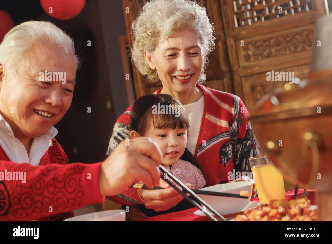 Happiness grandparents and granddaughter for dinner Stock Photo