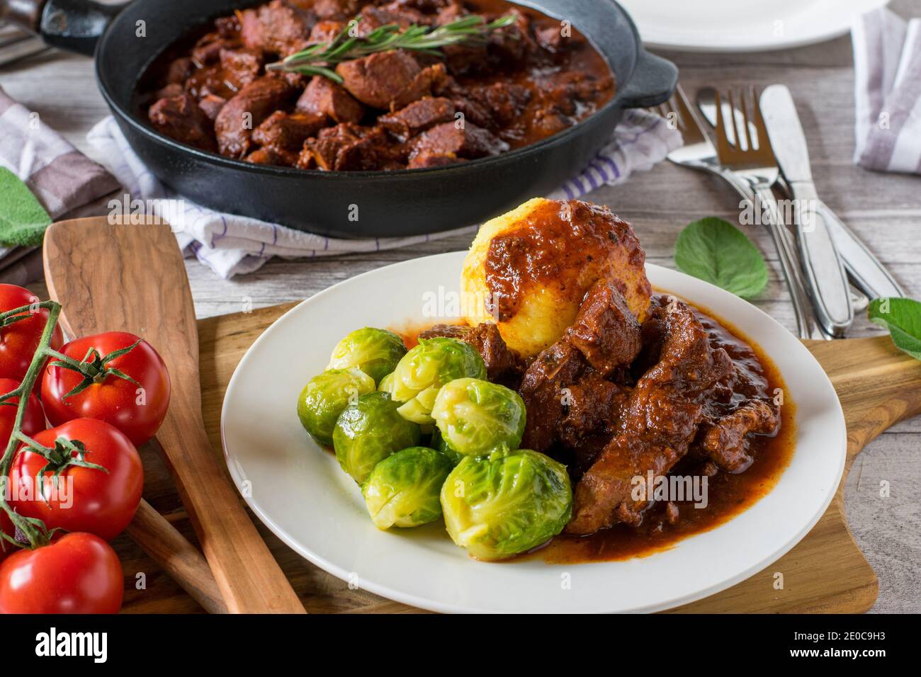 German Pork goulash with brussels sprouts and potato dumplings on a