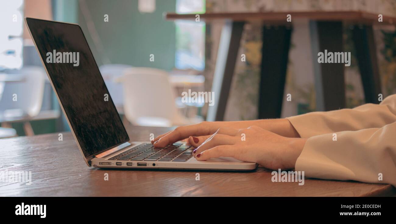 Woman hands typing on laptop computer keyboard at cafeteria, internet ...