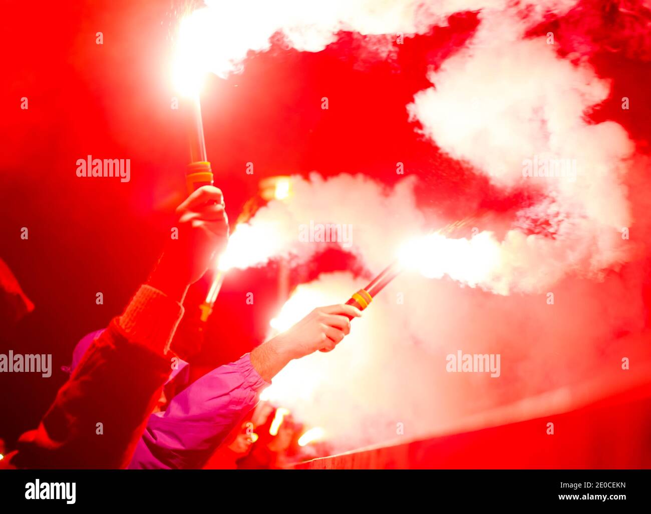 The protester is holding a fiery fire in his hands. Football fan burns fire Stock Photo