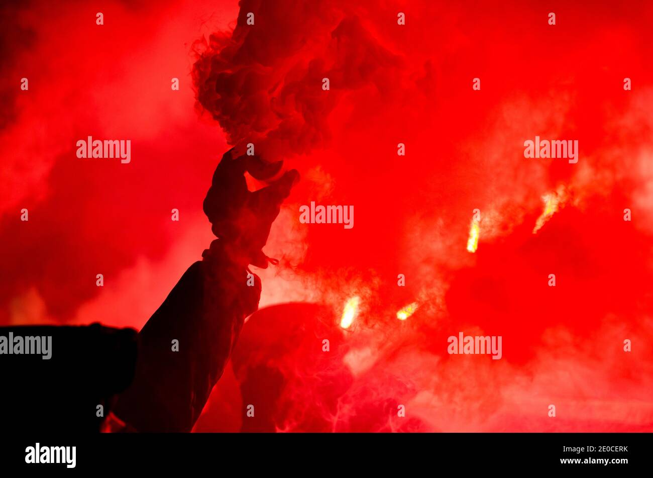 The protester is holding a fiery fire in his hands. Football fan burns fire Stock Photo