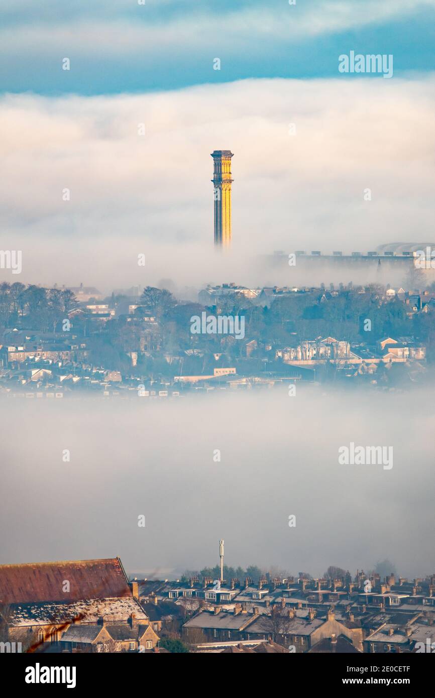 Bradford, West Yorkshire, UK. 31st Dec, 2020. Misty views across the valley in Bradford as the UK continues with a cold spell. The mighty industrial chimney of the former Listers Mill can be seen, catching the sunshine as it rises out of the fog, with a 5G telecoms mast in the lower foreground. Credit: Mick Flynn/Alamy Live News Stock Photo