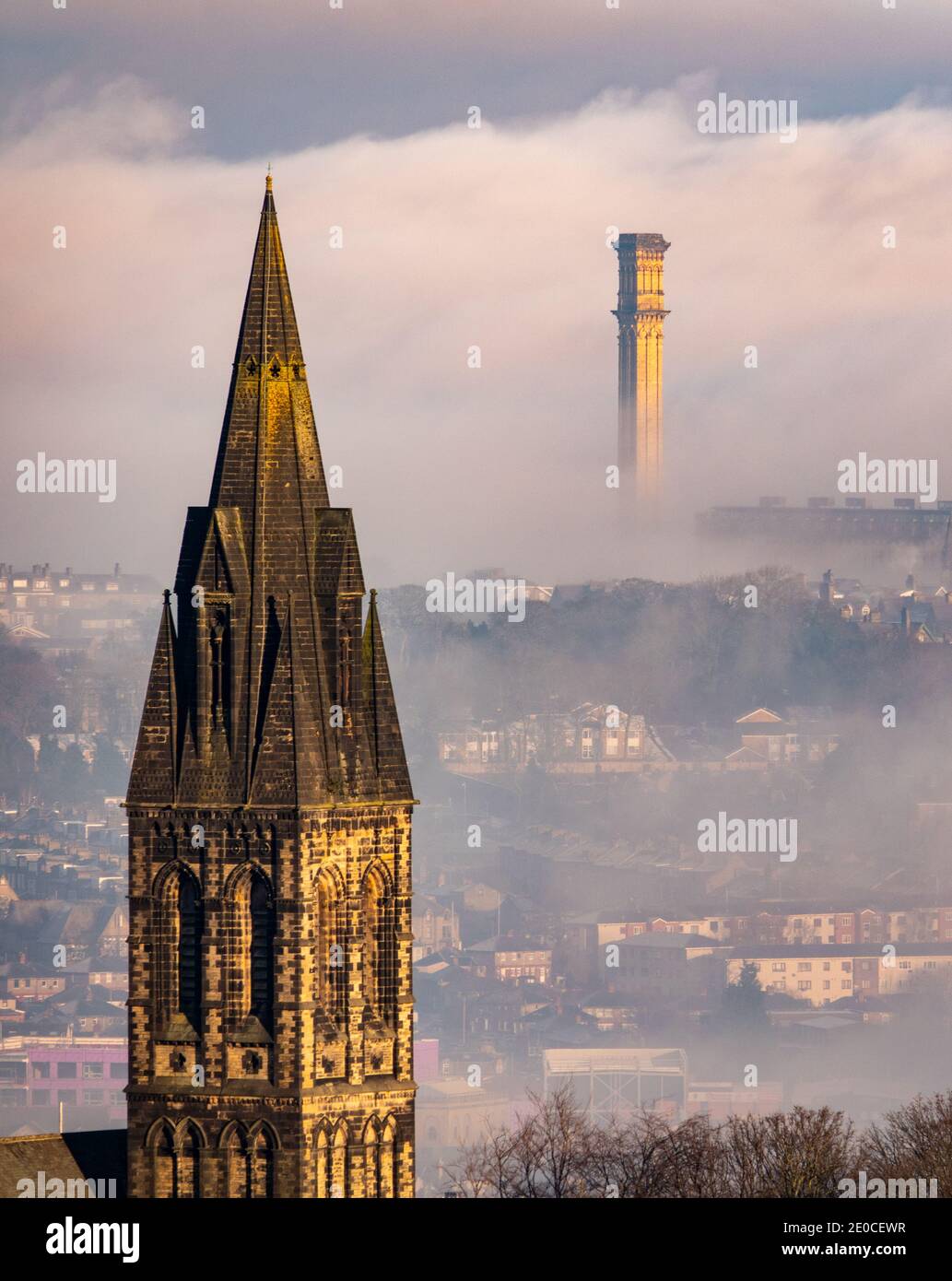 Bradford, West Yorkshire, UK. 31st Dec, 2020. Misty views across the valley in Bradford as the UK continues with a cold spell. The mighty industrial chimney of the former Listers Mill can be seen, catching the sunshine as it rises out of the fog. Credit: Mick Flynn/Alamy Live News Stock Photo