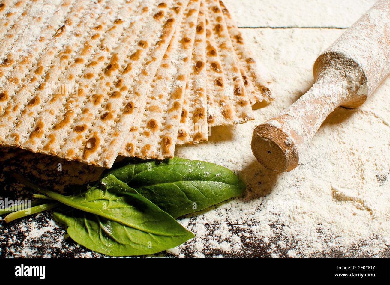 traditional Jewish kosher matzo for Easter pesah on a wooden table. Jewish Easter food. Spring. Flour and rolling pin. Preparation of matzo Stock Photo