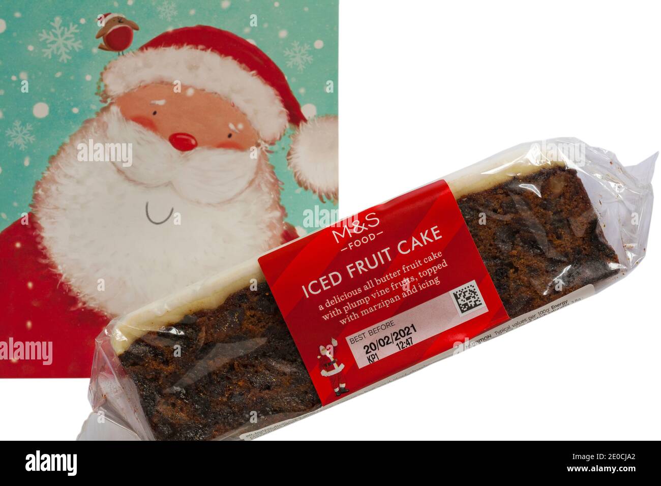 M&S Iced Fruit Cake Christmas Cake with Father Christmas Santa Claus card set on white background - UK festive Xmas Stock Photo