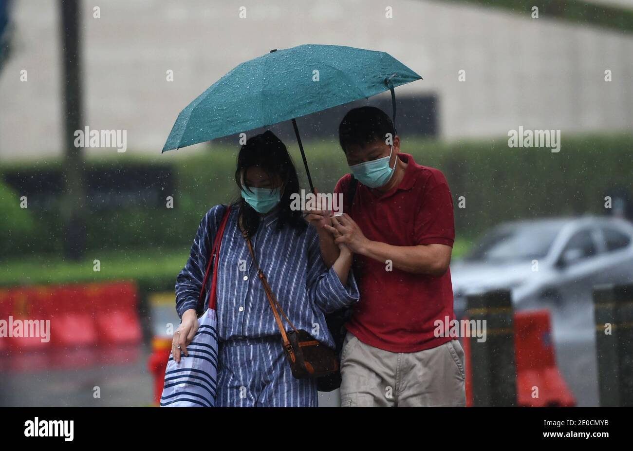 Jakarta, Indonesia. 31st Dec, 2020. Pedestrians wearing face masks walk in the rain in Jakarta, Indonesia, Dec. 31, 2020. The COVID-19 cases in Indonesia rose by 8,074 within one day to 743,198, with the death toll adding by 194 to 22,138, the Health Ministry said on Thursday. Credit: Zulkarnain/Xinhua/Alamy Live News Stock Photo
