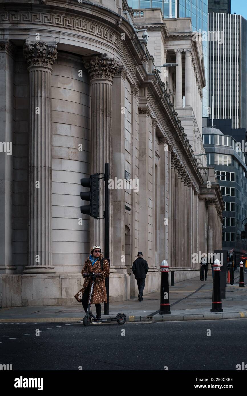 London, UK - December 2020 :  Man on a scooter in the City of London with quiet streets during Tier 4 lockdown Stock Photo