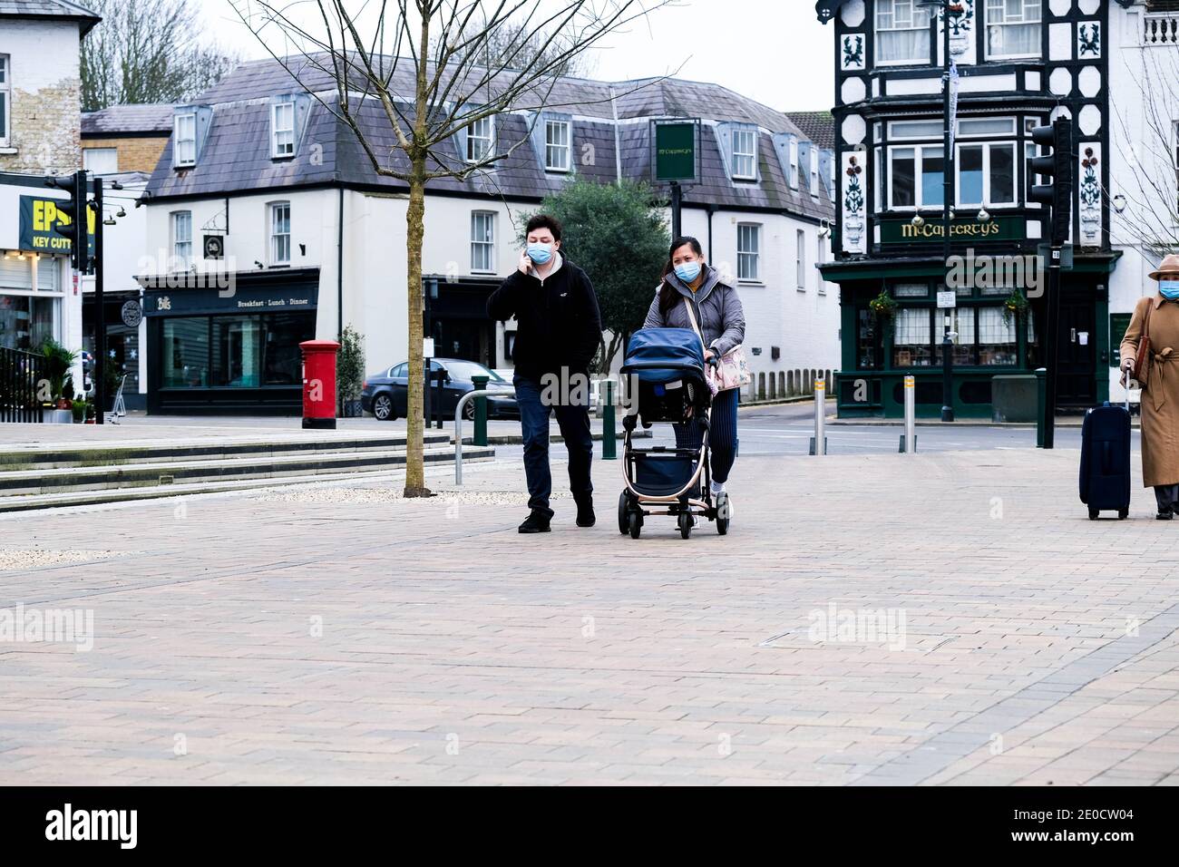 London UK, December 31 2020, Young Asian Couple With A Baby In A Pushchair Wearing Protective Face Masks During COVID-19 Tier 4 Lockdown Stock Photo
