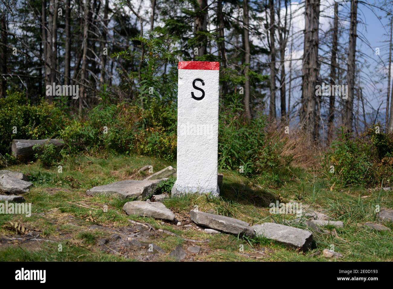 Boundary marker is marking border and borderline to Slovakia, foreign country and state. Stone, obelish pillar as marker in the nature. Stock Photo
