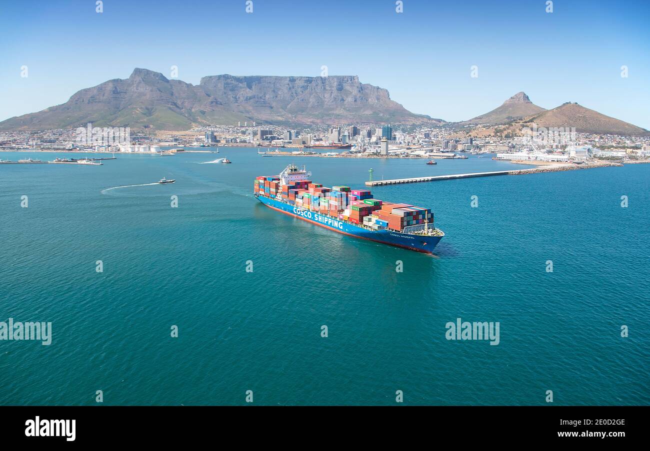 Cape Town, Western Cape, South Africa - 12.22.2020: Aerial photo of a container ship with tugs and Table Mountain in the background Stock Photo