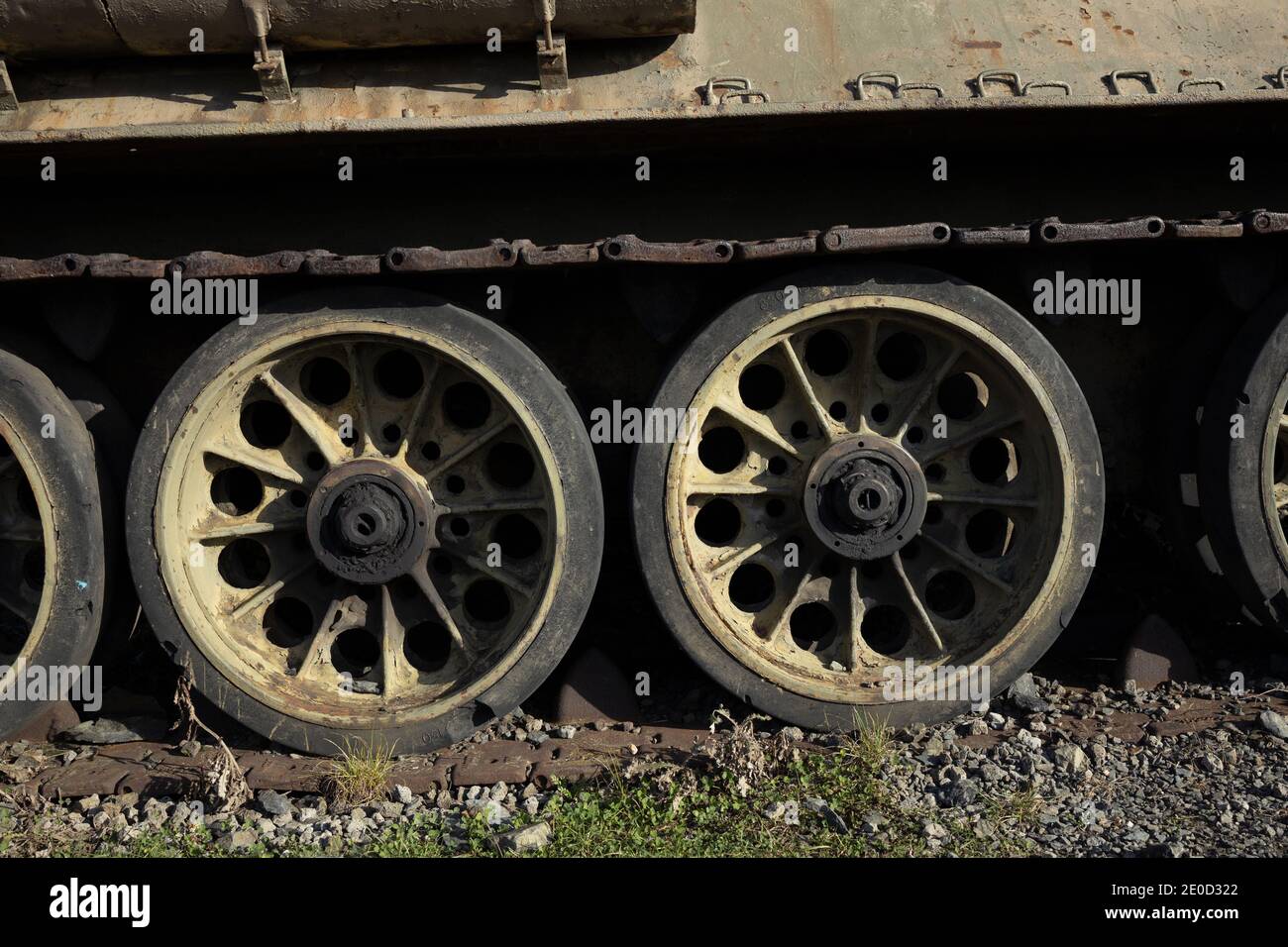 Detail of old aged military vehicle with continous track and wheels. Tank is corroded, rusty, tarnished and faded. Stock Photo
