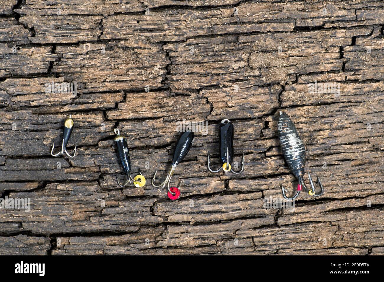 Set of lures for ice fishing shot from above on a cracked wooden background. Stock Photo